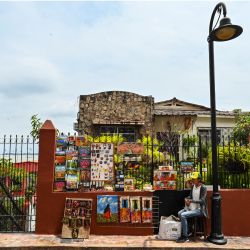 Un pintor vende sus cuadros en una calle del cerro Santa Ana en la ciudad portuaria de Guayaquil, Ecuador. | Foto:LUIS ACOSTA / AFP