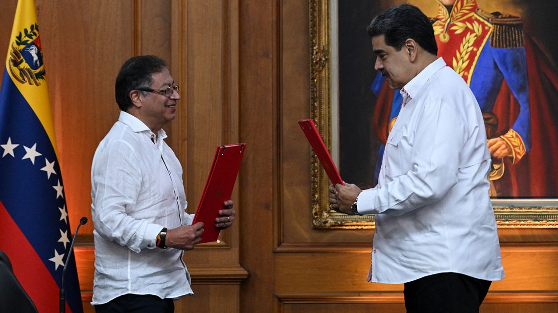 Colombian President Gustavo Petro and his Venezuelan counterpart Nicolás Maduro exchange documents after signing a agreements at Miraflores Presidential Palace in Caracas, on November 1, 2022.