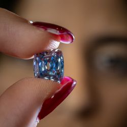 Una modelo sostiene un diamante De Beers de talla brillante cojín de 5,53 quilates que podría alcanzar los 15 millones de dólares estadounidenses durante un avance de prensa de la casa de subastas Sotheby's antes de su venta en Ginebra. | Foto:FABRICE COFFRINI / AFP