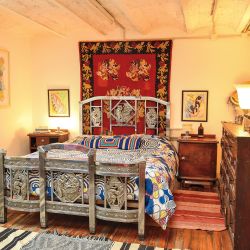  En el cuarto principal, el acolchado de patchwork de telas africanas contrasta con los muebles de época y con las obras de arte.