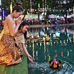 La gente suelta linternas flotantes en un estanque durante el festival Loy Kratong en Bangkok, Tailandia. | Foto:LILLIAN SUWANRUMPHA / AFP
