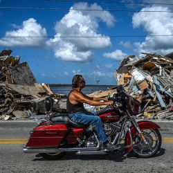 Un motociclista pasa junto a los escombros apilados de una casa destruida tras el paso del huracán Ian en la isla de Matlacha, en el condado de Lee, Florida. | Foto:Giorgio Viera / AFP