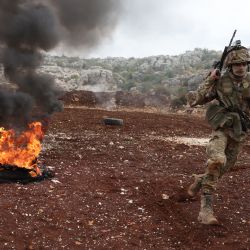 Combatientes afiliados al grupo rebelde sirio "Hayat Tahrir al-Sham", participan en un ejercicio militar sobre tácticas de ataque con munición real, en las afueras de la provincia noroccidental de Idlib. | Foto:OMAR HAJ KADOUR / AFP