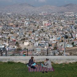 Unos hombres beben té en la cima de la colina de Wazir Akbar Khan, con vistas a Kabul, Afganistán. | Foto:WAKIL KOHSAR / AFP