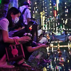 La gente suelta linternas flotantes en un estanque durante el festival Loy Kratong en Bangkok, Tailandia. | Foto:LILLIAN SUWANRUMPHA / AFP
