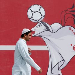 Un hombre pasa junto a un cartel de la mascota de Qatar 2022, La'eeb, en Doha, antes del torneo de fútbol de la Copa Mundial de la FIFA Qatar 2022. | Foto:ODD ANDERSEN / AFP