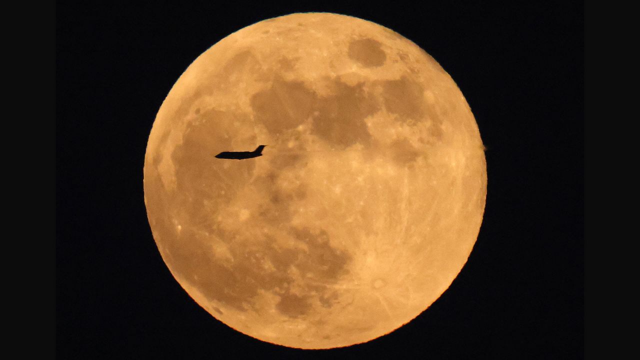 Un avión de línea comercial vuela ante la luna llena creciente sobre la ciudad de Kuwait. | Foto:YASSER AL-ZAYYAT / AFP
