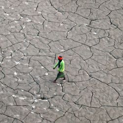 Un hombre camina por el lecho de un río seco a orillas del río Ganges, en Prayagraj, India. | Foto:SANJAY KANOJIA / AFP