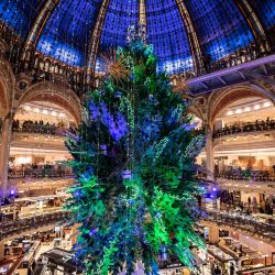 El Árbol de Navidad en el interior de las Galerías Lafayette es fotografiado durante la noche de apertura de los escaparates de Navidad en los grandes almacenes Galeries Lafayette en París. | Foto:BERTRAND GUAY / AFP