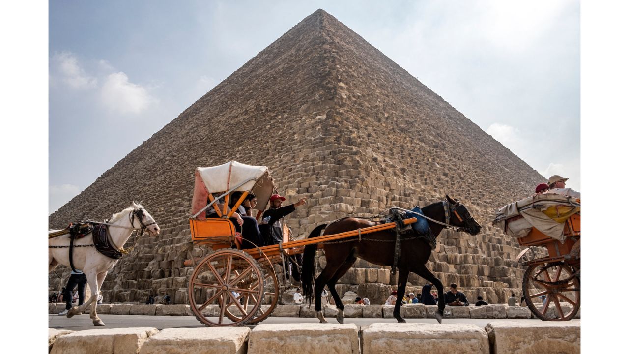 Personas montan en carros tirados por caballos frente a la Gran Pirámide del antiguo rey egipcio Khufu (construida alrededor del 2570 a.C.) en la necrópolis de Giza, en las afueras de la capital de Egipto. | Foto:AMIR MAKAR / AFP