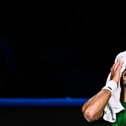 El serbio Novak Djokovic se limpia la cara antes de someterse a una nueva evaluación médica de un fisioterapeuta durante su partido de octavos de final contra el ruso Daniil Medvedev en el torneo de tenis ATP Finals en Turín. | Foto:MARCO BERTORELLO / AFP