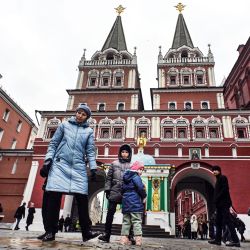 Turistas caminan en el Punto Kilométrico Cero de Rusia frente a Voskresenskiye Vorota (Puertas de la Resurrección) en el borde de la Plaza Roja en Moscú. | Foto:ALEXANDER NEMENOV / AFP