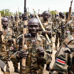 Los nuevos miembros de las Fuerzas de Defensa del Pueblo de Sudán del Sur (SSPDF) de las Fuerzas Unificadas asisten con rifles o palos de madera hechos a mano durante la ceremonia de graduación en Malakal. | Foto:Samir Bol / AFP