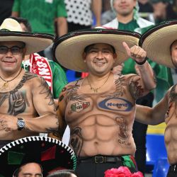 Seguidores de México con camisetas inspiradas en tatuajes animan antes del partido de fútbol del Grupo C de la Copa del Mundo Qatar 2022 entre México y Polonia en el Estadio 974 de Doha. | Foto:ANDREJ ISAKOVIC / AFP