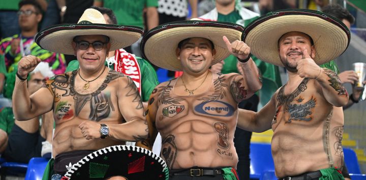 Seguidores de México con camisetas inspiradas en tatuajes animan antes del partido de fútbol del Grupo C de la Copa del Mundo Qatar 2022 entre México y Polonia en el Estadio 974 de Doha.