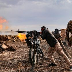 Un combatiente sirio dispara una ametralladora montada en la parte trasera de una motocicleta durante los ejercicios militares de la "División Suleiman Shah", respaldada por Turquía, en la región de Afrin, controlada por la oposición, en el norte de Siria. | Foto:BAKR ALKASEM / AFP