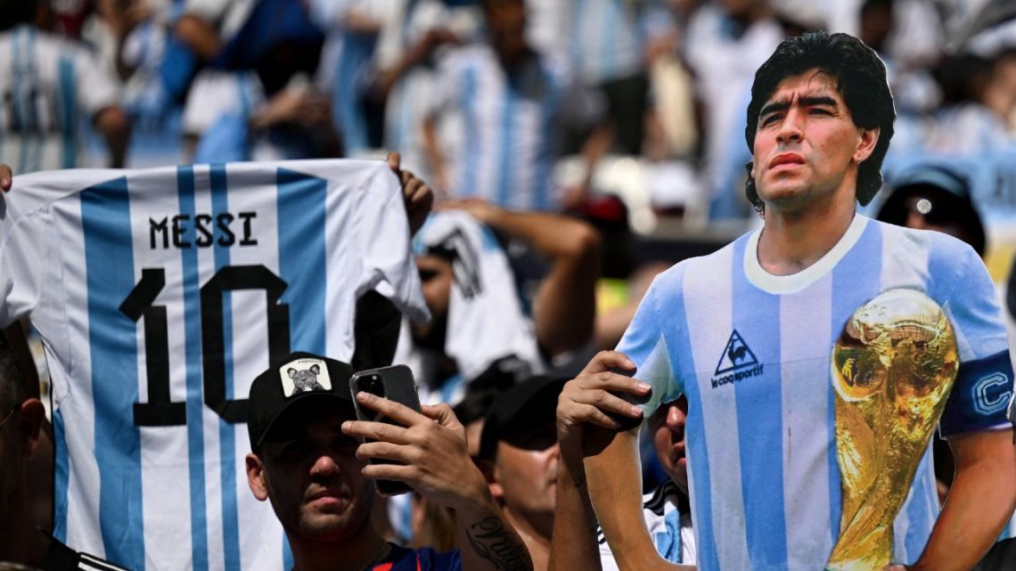 Argentina's suporters wave a Lionel Messi shirt and an effigy depicting the late Diego Maradona before the start of the Qatar 2022 World Cup Group C football match between Argentina and Saudi Arabia at the Lusail Stadium in Lusail, north of Doha on November 22, 2022.