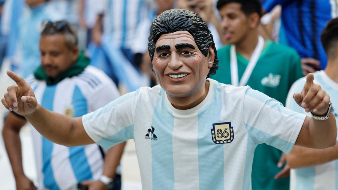 An Argentina fan wears a 1986 replica Albiceleste shirt and a mask featuring – we think – the face of Diego Maradona ahead of Argentina's World Cup group stage match against Saudi Arabia at the Qatar 2022 World Cup.