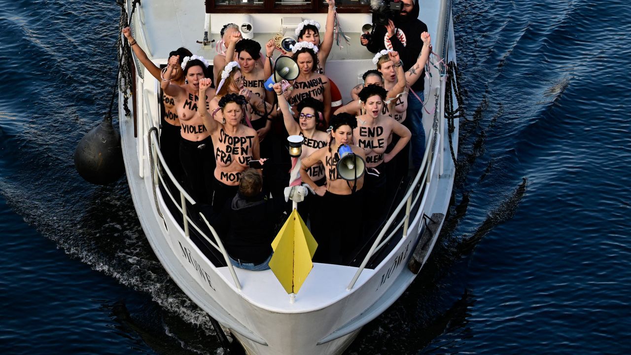 Activistas del grupo activista feminista Femen gritan consignas mientras se encuentran en un barco en el río Spree durante una acción de protesta en el Día Internacional de la Eliminación de la Violencia contra la Mujer, en el centro de la capital alemana, Berlín. | Foto:JOHN MACDOUGALL / AFP