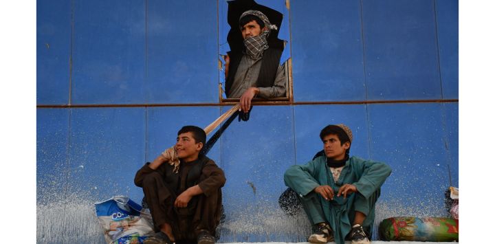 Afganos observan a jinetes compitiendo durante el "Buzkashi", un deporte tradicional de Asia Central, en Mazar-i-Sharif.