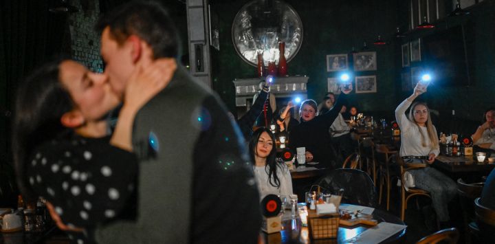 Una pareja se besa en un bar durante un corte de luz en Kiev, en medio de la invasión rusa de Ucrania.