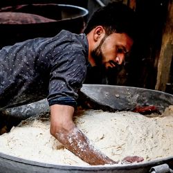 Un trabajador amasa la masa para preparar roti - una forma de pan popular en la India en una panadería que hace panes roti, en la zona de la ciudad amurallada de Nueva Delhi. | Foto:Sajjad Hussain / AFP