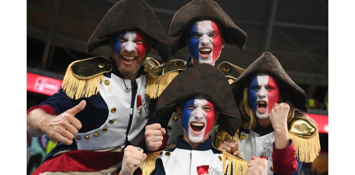 Seguidores de Francia con disfraces de Napoleón y la cara pintada animan antes del comienzo del partido de fútbol del Grupo D de la Copa del Mundo Qatar 2022 entre Francia y Dinamarca en el Estadio 974 en Doha.
