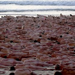 Los participantes posan desnudos durante el amanecer en la playa de Bondi de Sídney para el fotógrafo de arte estadounidense Spencer Tunick, para concienciar sobre el cáncer de piel. | Foto:SAEED KHAN / AFP