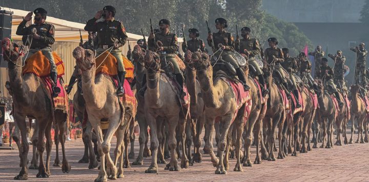 El personal de la Fuerza de Seguridad Fronteriza (BSF) monta en camellos mientras participa en un ensayo antes del 58º Día de Levantamiento de la BSF en la Universidad Guru Nanak Dev en Amritsar, India.