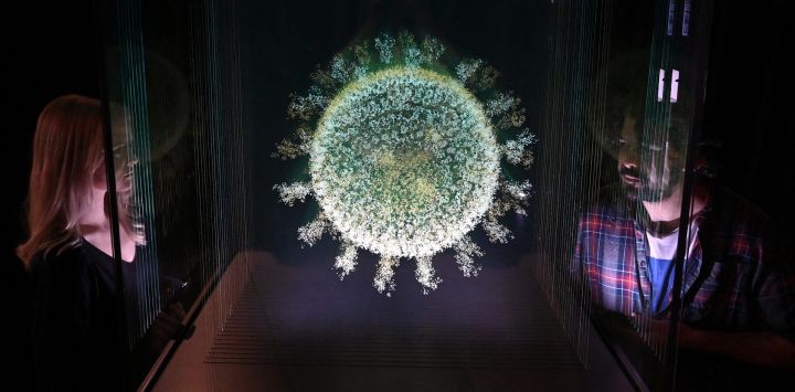El personal del museo posa con una escultura titulada "La esfera que cambió el mundo", de Angela Palmer, durante el photocall de la exposición "Injecting Hope: The race for a COVID-19 vaccine", en el Museo de la Ciencia de Londres.