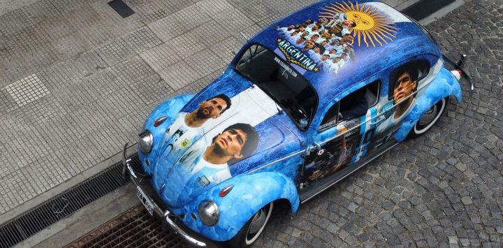 Vista de un Volkswagen 1960 pintado con imágenes de jugadores de la selección argentina de fútbol en Buenos Aires. - El coche fue diseñado por la diseñadora Luz Baliña y es propiedad de su padre Carlos, como un proyecto familiar.