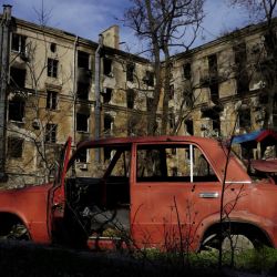 Esta fotografía muestra un coche dañado frente a las ruinas en la ciudad portuaria de Mariupol, ocupada por Rusia, en el sureste de Ucrania. | Foto:STRINGER / AFP