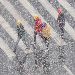 La gente camina por una carretera durante una nevada en Yantai, en la provincia oriental china de Shandong. | Foto:AFP