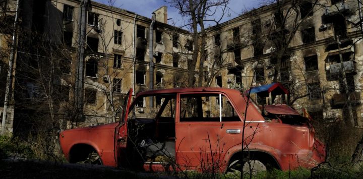 Esta fotografía muestra un coche dañado frente a las ruinas en la ciudad portuaria de Mariupol, ocupada por Rusia, en el sureste de Ucrania.