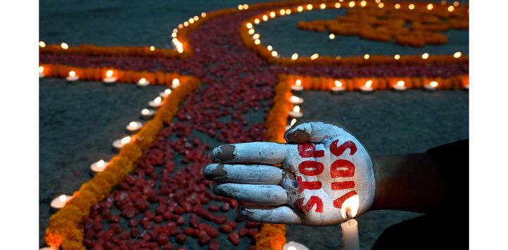 Un activista social pinta la palma de su mano con el mensaje "Stop AIDS" durante una campaña de concienciación organizada para celebrar el "Día Mundial del SIDA" en Calcuta, India.