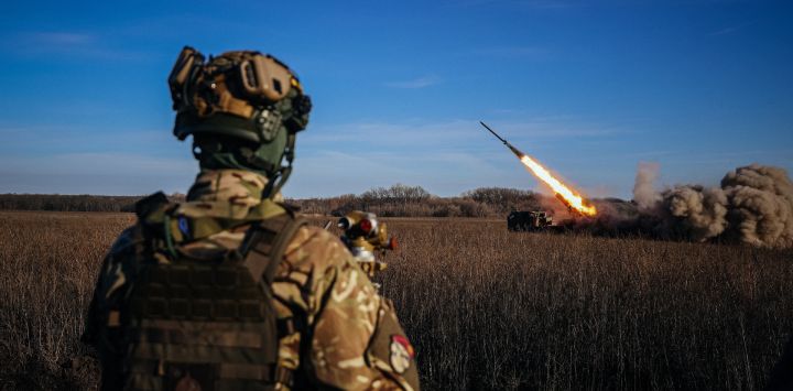 Un soldado ucraniano observa un lanzacohetes múltiple autopropulsado de 220 mm "Bureviy" disparando hacia las posiciones rusas en la línea del frente, en el este de Ucrania, en medio de la invasión rusa de Ucrania.