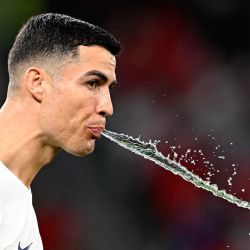 El delantero de Portugal Cristiano Ronaldo escupe agua antes del comienzo del partido de fútbol del Grupo H de la Copa del Mundo de Qatar 2022 entre Corea del Sur y Portugal en el Estadio de la Ciudad de la Educación en Al-Rayyan, al oeste de Doha. | Foto:PATRICIA DE MELO MOREIRA / AFP