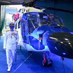 El Director General de los guardacostas indios, VS Pathania, gesticula junto a un Helicóptero Ligero Avanzado Indígena (ALH -MkIII) durante una ceremonia de puesta en marcha del Escuadrón 840 en la estación aérea de los guardacostas indios en Chennai. | Foto:ARUN SANKAR / AFP