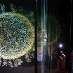 Un miembro del personal del museo posa con una escultura titulada "La esfera que cambió el mundo", de Angela Palmer, durante el photocall de la exposición "Injecting Hope: The race for a COVID-19 vaccine", en el Museo de la Ciencia de Londres. | Foto:JUSTIN TALLIS / AFP