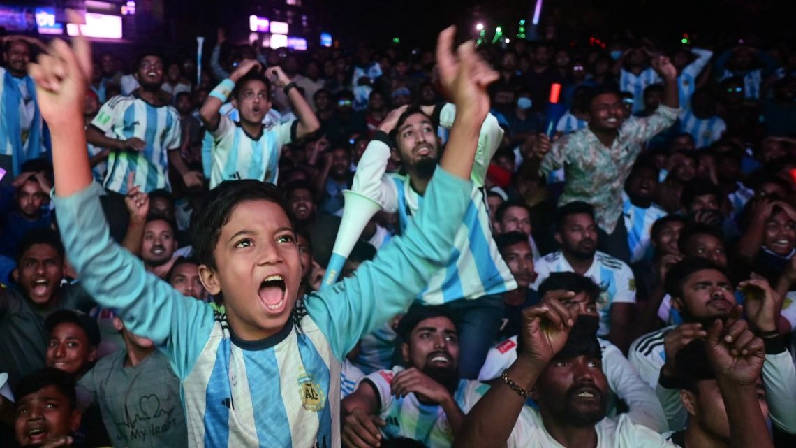 Football fans react as they watch the Qatar 2022 World Cup Group C football match between Poland and Argentina on a big screen, in Dhaka, on December 1, 2022. 