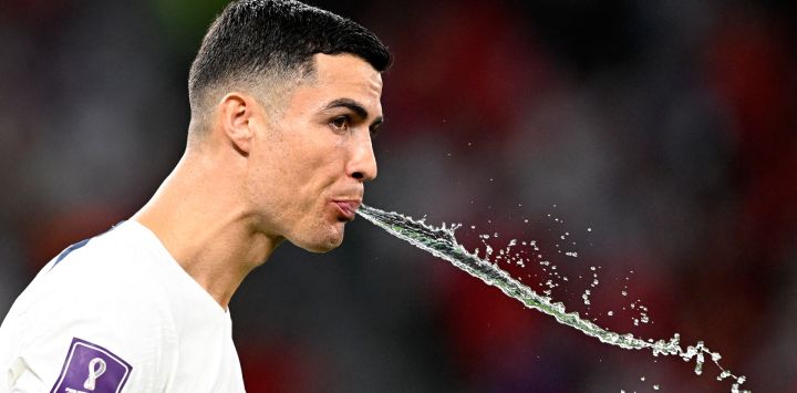 El delantero de Portugal Cristiano Ronaldo escupe agua antes del comienzo del partido de fútbol del Grupo H de la Copa del Mundo de Qatar 2022 entre Corea del Sur y Portugal en el Estadio de la Ciudad de la Educación en Al-Rayyan, al oeste de Doha.