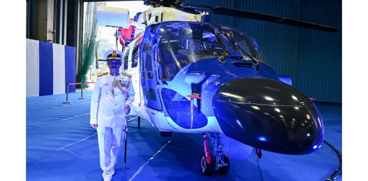 El Director General de los guardacostas indios, VS Pathania, gesticula junto a un Helicóptero Ligero Avanzado Indígena (ALH -MkIII) durante una ceremonia de puesta en marcha del Escuadrón 840 en la estación aérea de los guardacostas indios en Chennai.