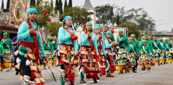 Miembros de Danza Guadalupana actúan en la 91ª Procesión y Misa en honor a Nuestra Señora de Guadalupe y San Juan Diego, en la comunidad tradicionalmente latina de East Los Angeles, en Los Ángeles, California.