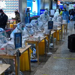 Trabajadores sanitarios esperan para realizar las pruebas del coronavirus Covid-19 a los pasajeros tras su llegada a la estación de tren de Hongqiao, en Shanghái, China. | Foto:HECTOR RETAMAL / AFP