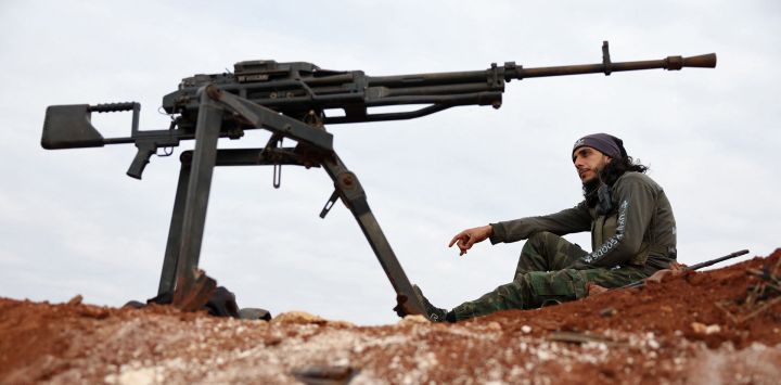 Un combatiente sirio respaldado por Turquía se sienta en una posición en las afueras de la ciudad de Marea, en el norte del campo de Alepo, a lo largo de la línea del frente con las áreas en poder de la alianza kurdo-árabe respaldada por Estados Unidos conocida como las Fuerzas Democráticas Sirias (SDF).