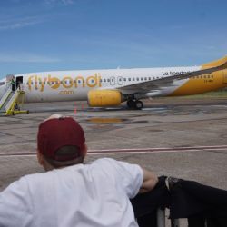 A person watches as a FB Líneas Aéreas SA (Flybondi) airplane arrives in Buenos Aires.