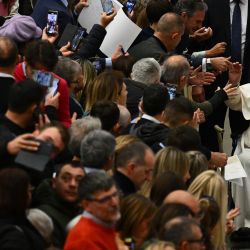 El papa Francisco, sentado en una silla de ruedas, se reúne con los asistentes durante la audiencia general semanal en la sala Pablo VI del Vaticano. | Foto:Vincenzo Pinto / AFP