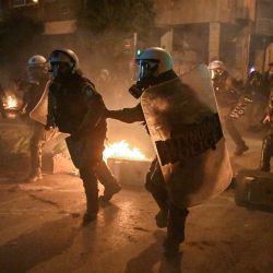 La policía persigue a manifestantes durante los enfrentamientos que se produjeron al margen de una concentración contra la violencia policial, con motivo del 14º aniversario de la muerte de un adolescente en 2008 por disparos de la policía en el barrio de Exarchia, en el centro de Atenas, Grecia. | Foto:LOUISA GOULIAMAKI / AFP