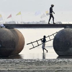 Obreros construyen un puente flotante de pontones sobre el río Ganges durante los preparativos de la próxima feria religiosa anual hindú de Magh Mela en Prayagraj, India. | Foto:SANJAY KANOJIA / AFP