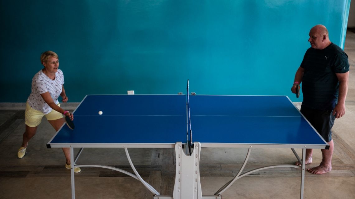 A couple of Russian tourists play table tennis while resting at a hotel complex on the beach in Isla Margarita, Nueva Esparta state, Venezuela, on November 26, 2022.